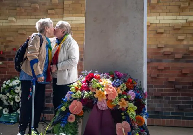 Deux femmes s’embrassent lors de l’inauguration du nouveau cimetière et mémorial dédié aux personnes queer, aménagé par le Schwulenberatung Berlin dans le cimetière St. Matthäus de Berlin. KEYSTONE - FABIAN SOMMER
